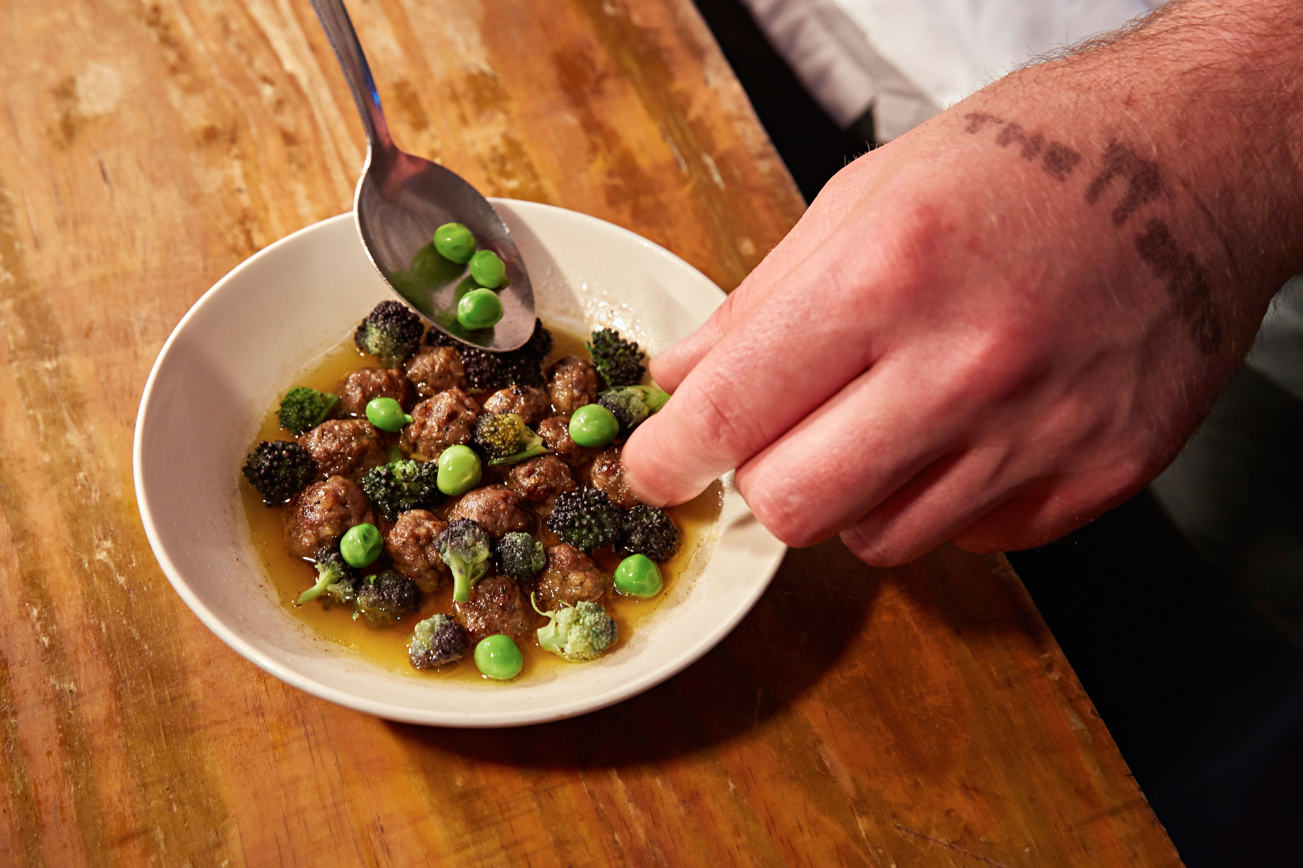 The dish of peas and wild garlic broth and veal balls is delicately prepared