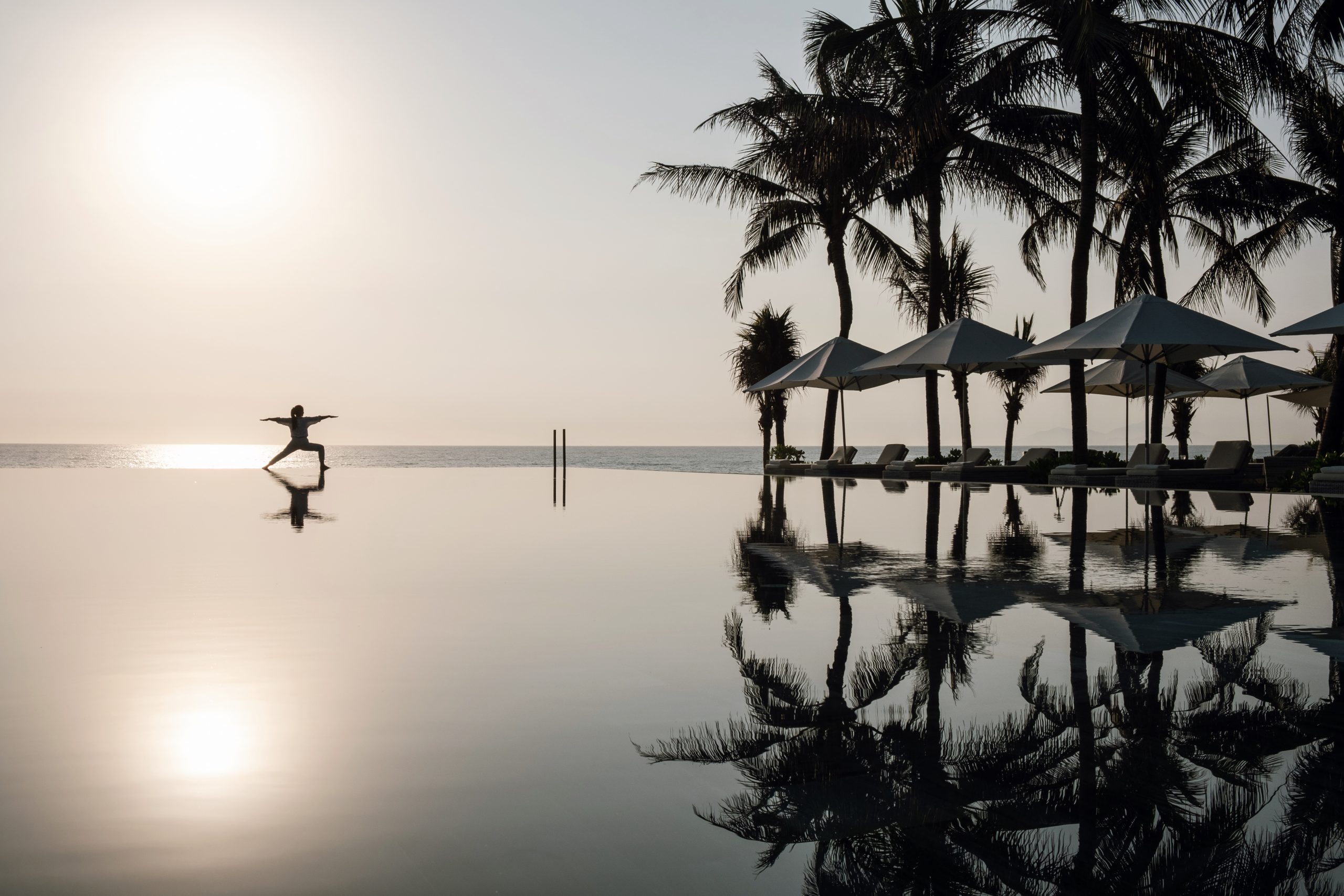 TIA Wellness Resort in Vietnam Person doing yoga on the beach at TIA Wellness Resort, Vietnam