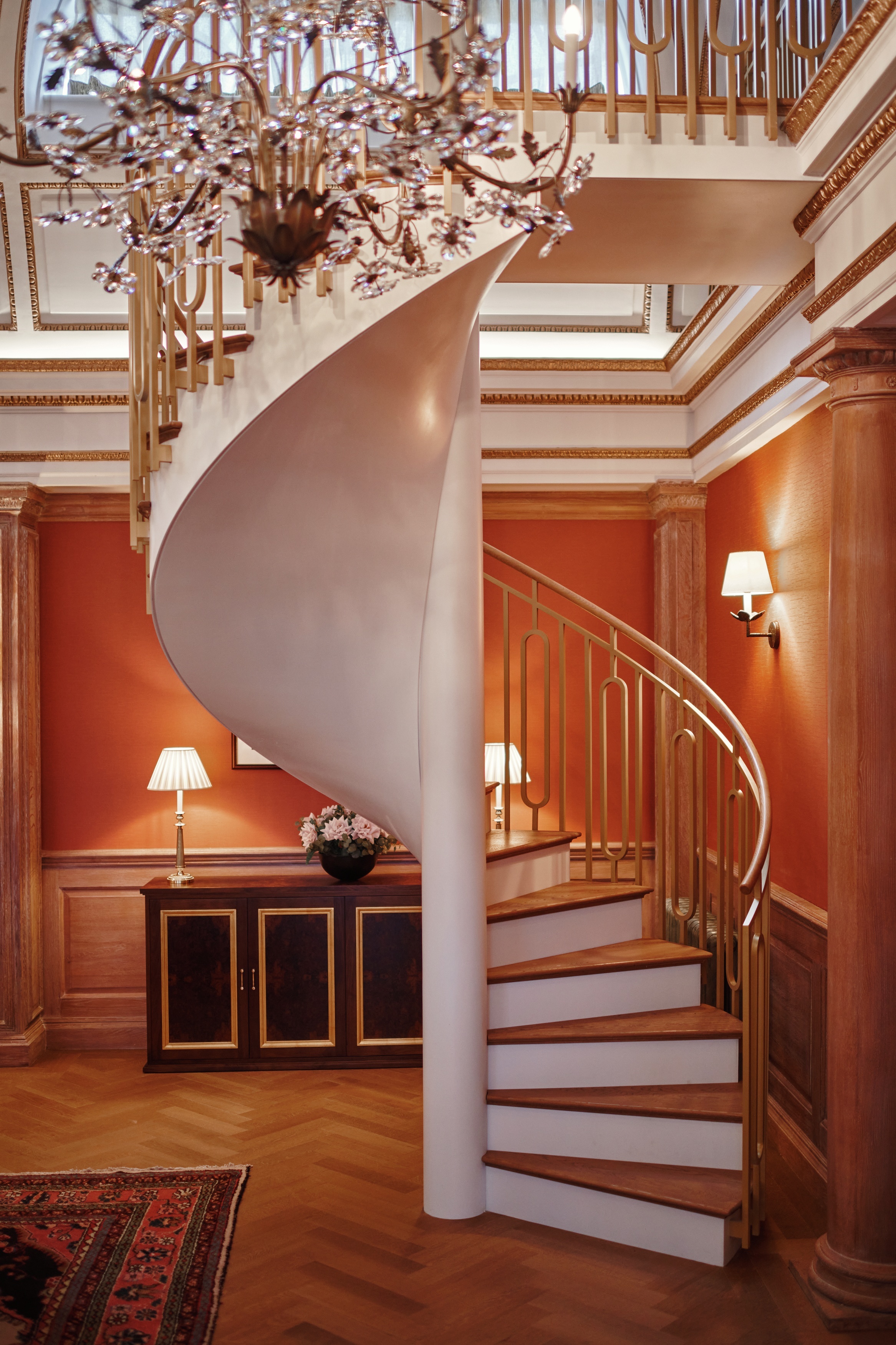 A spiral staircase links two levels of the duplex at The Astor duplex