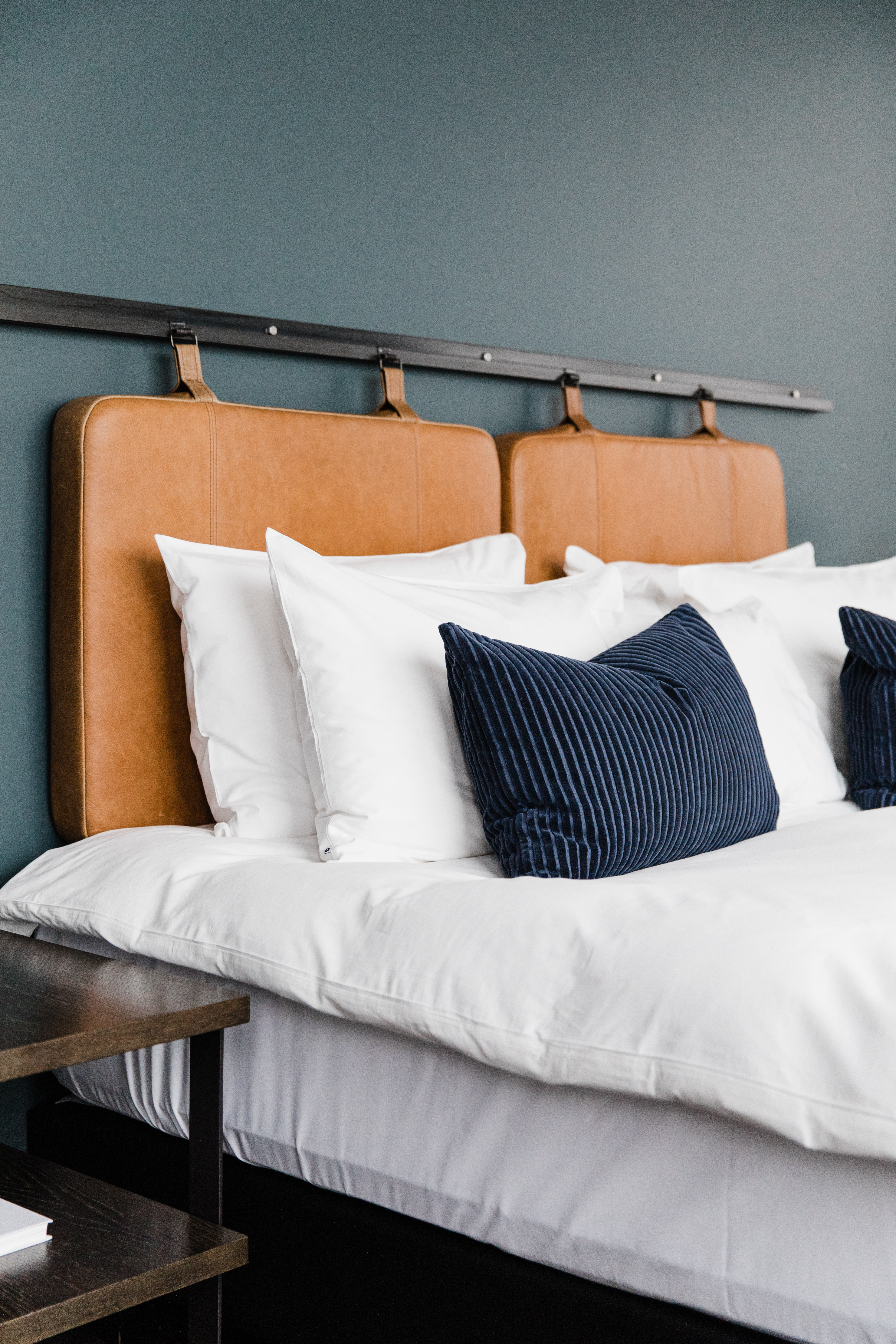 Hotel Exeter - Bedroom Hotel Exeter - a bed with white sheets, blue cushions and an orange headboard on a grey wall