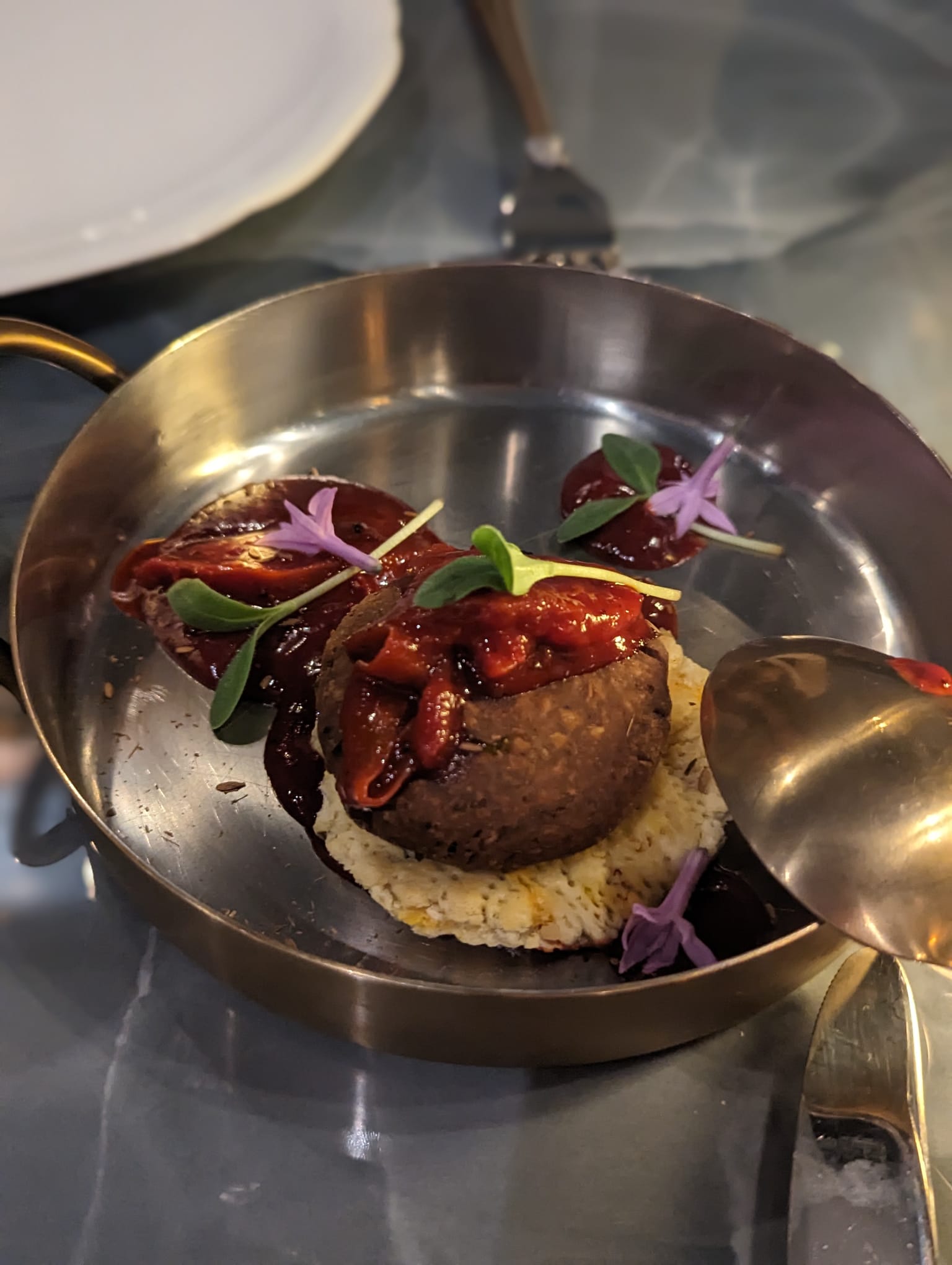 VATAVARAN - a potato dish on a silver plate with red sauce and leaves