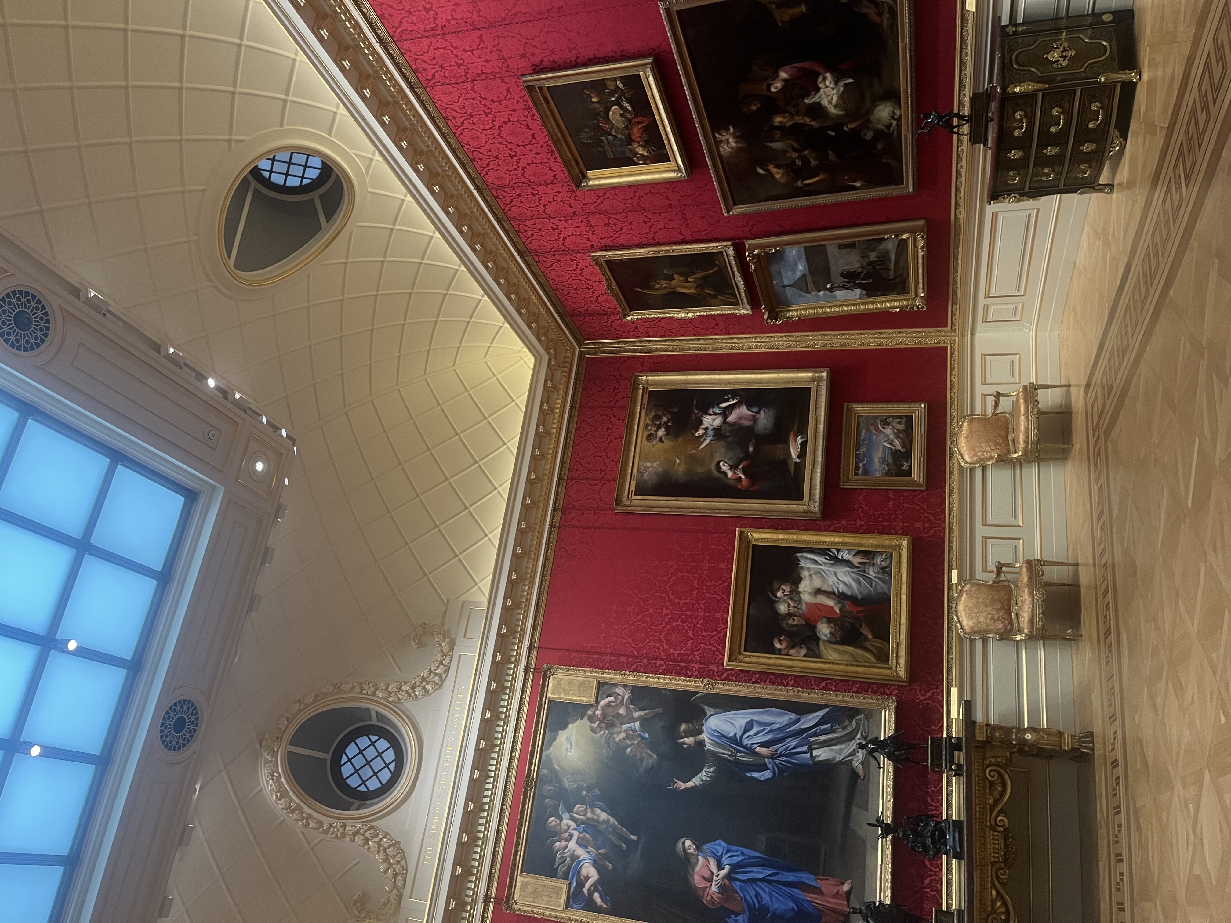 An art gallery room at The Wallace Collection with red walls, ornate ceilings, and large paintings in Marylebone.