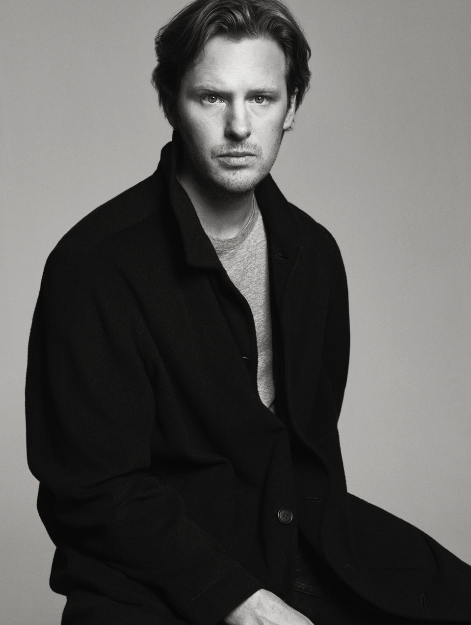 SPHERE FT Business of Luxury Summit Barcelona - Karl Lindman of Toteme sat on a stool in black and white