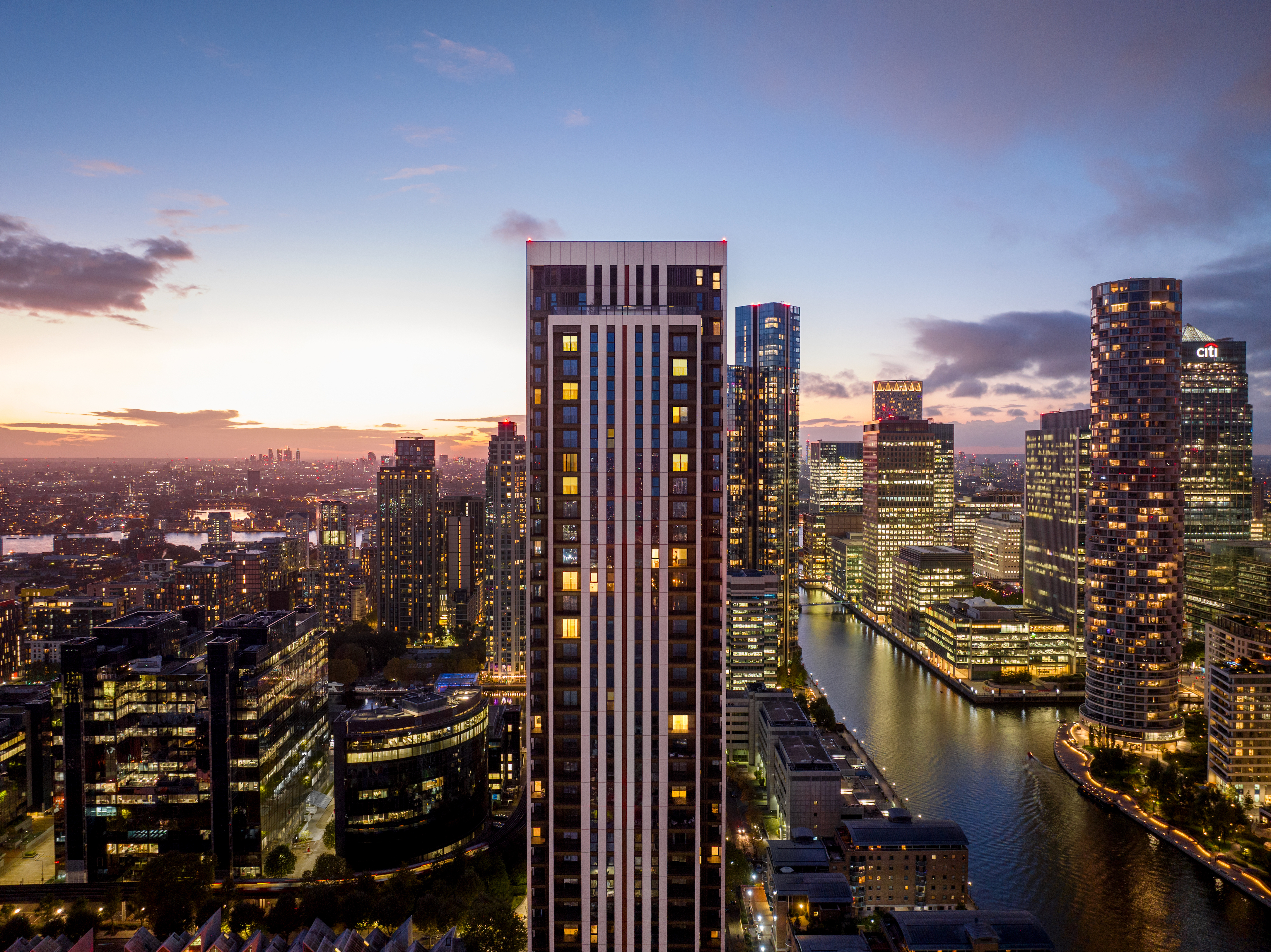 One Thames Quay at night alongside other buildings in the Canary Wharf skyline