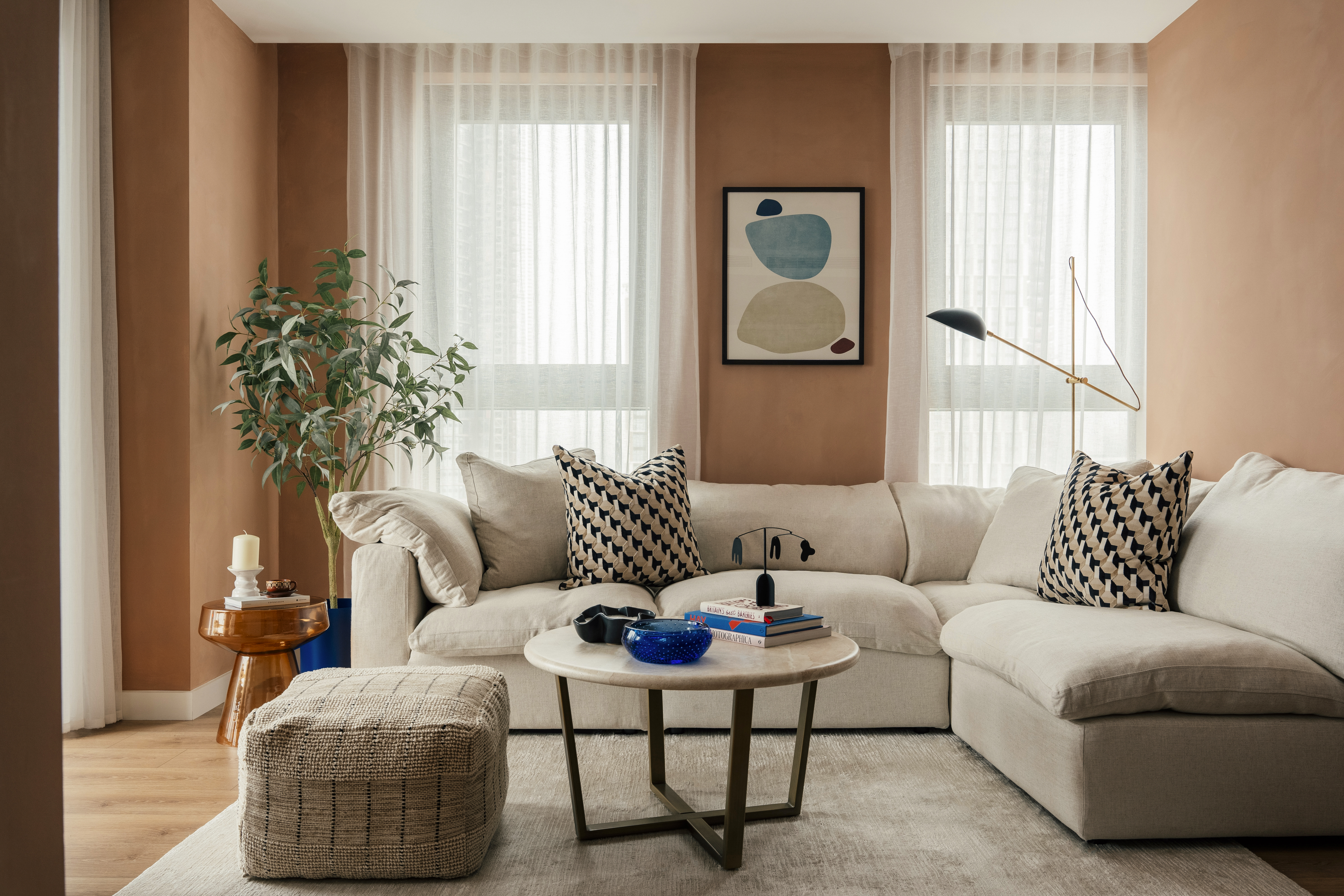 Property of the Week One Thames Quay - A stylish living room at One Thames Quay with a neutral L-shaped sofa, patterned cushions and a round coffee table