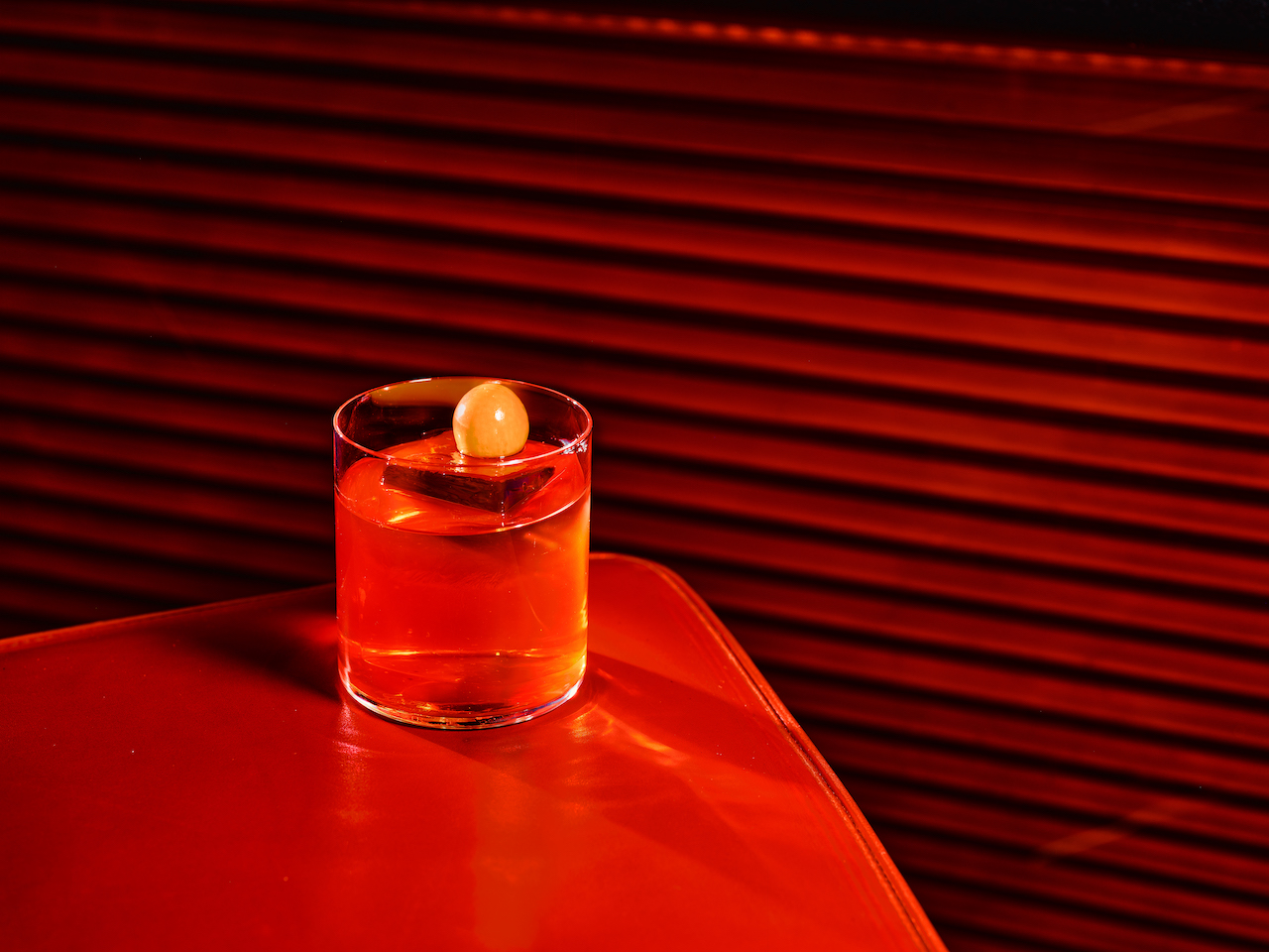 BAR45 Simplicity Cocktail - the orange Italo-Samba cocktail sat on an orange table.