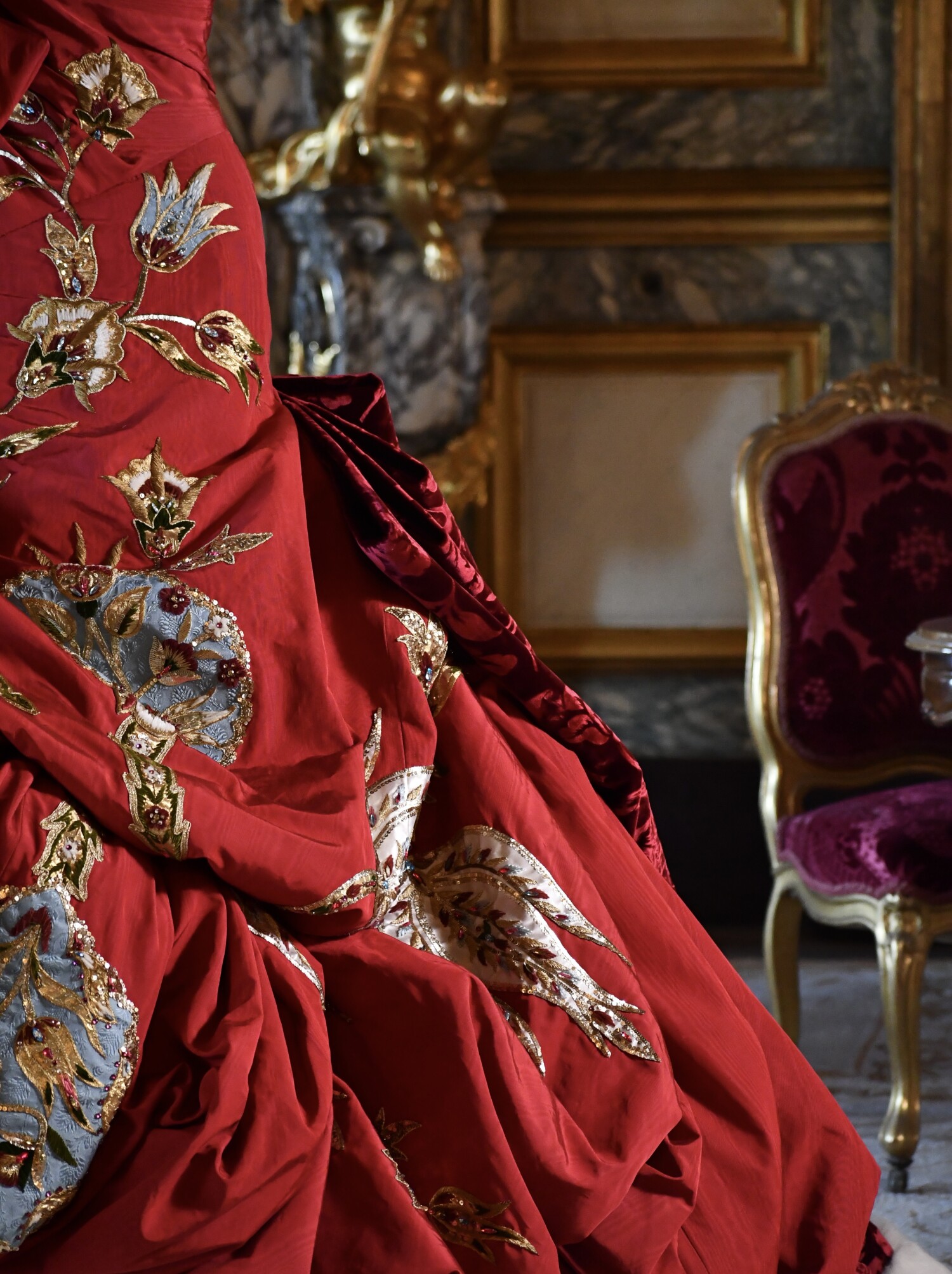 An embroidered red velvet gown from Christian Dior by John Galliano displayed at the Louvre Couture exhibition in Paris.