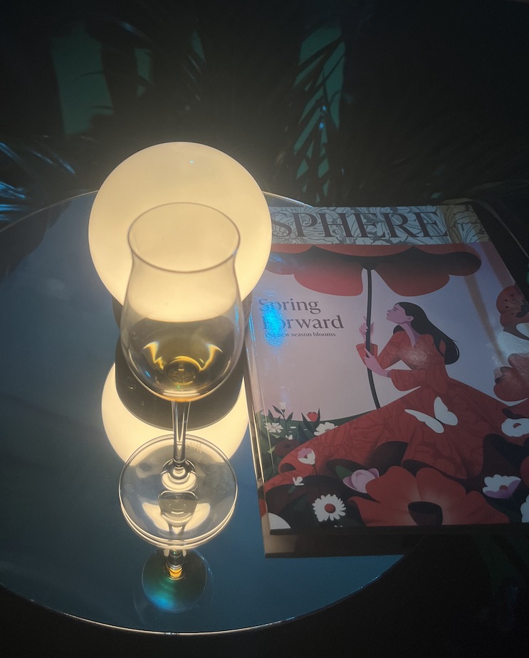 A tasting glass of Bowmore ARC-54 alongside a SPHERE spring issue.