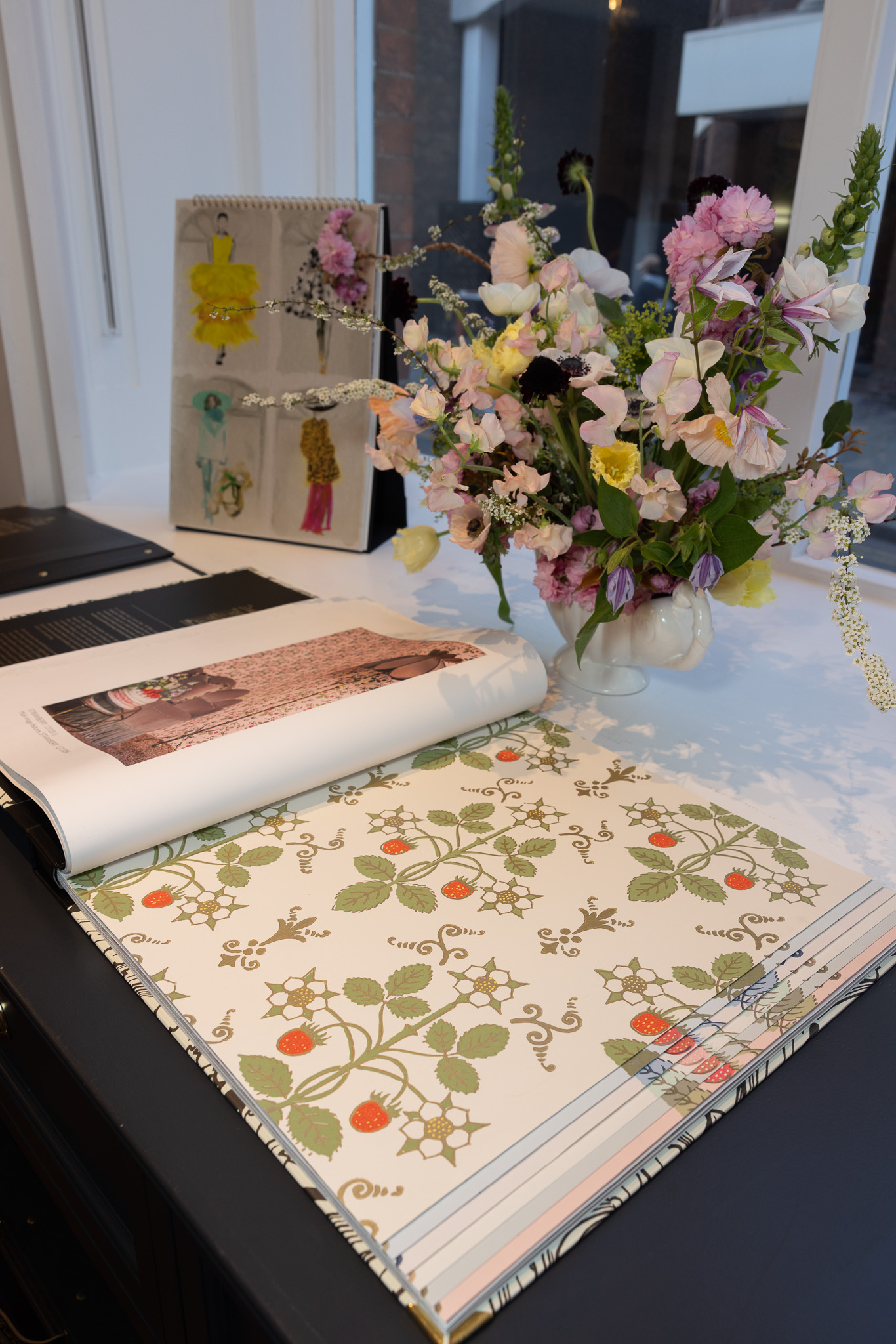 SPHERE magazine displaying an advertisement for Cole & Son alongside flowers and sketchbooks.