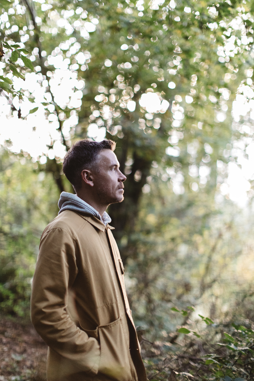 Nicholas Balfe, Chef Director of HOLM, stood in the forest amongst trees during a session of foraging.