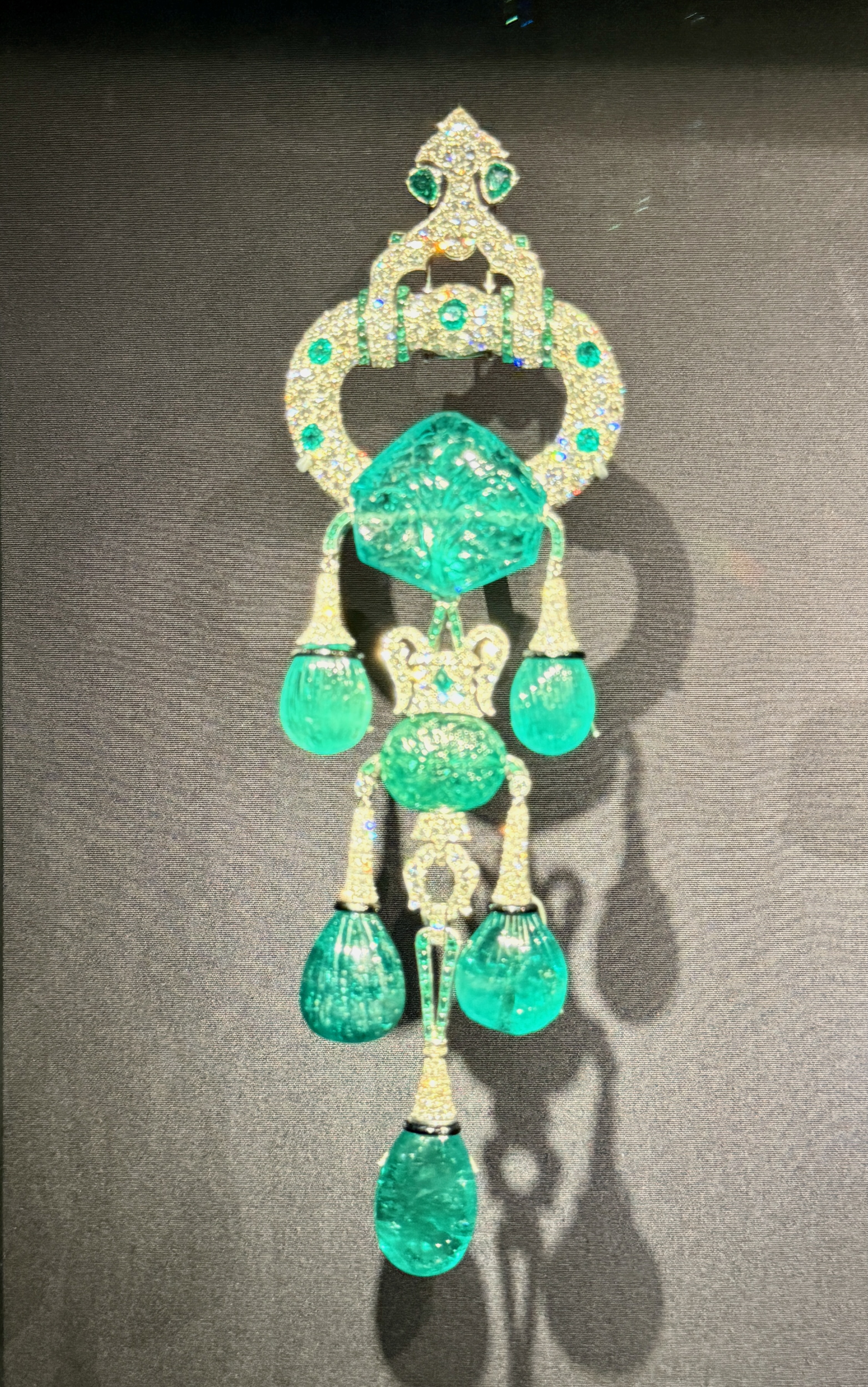 A Cartier dangling emerald shoulder clip brooch on display at the V&A.
