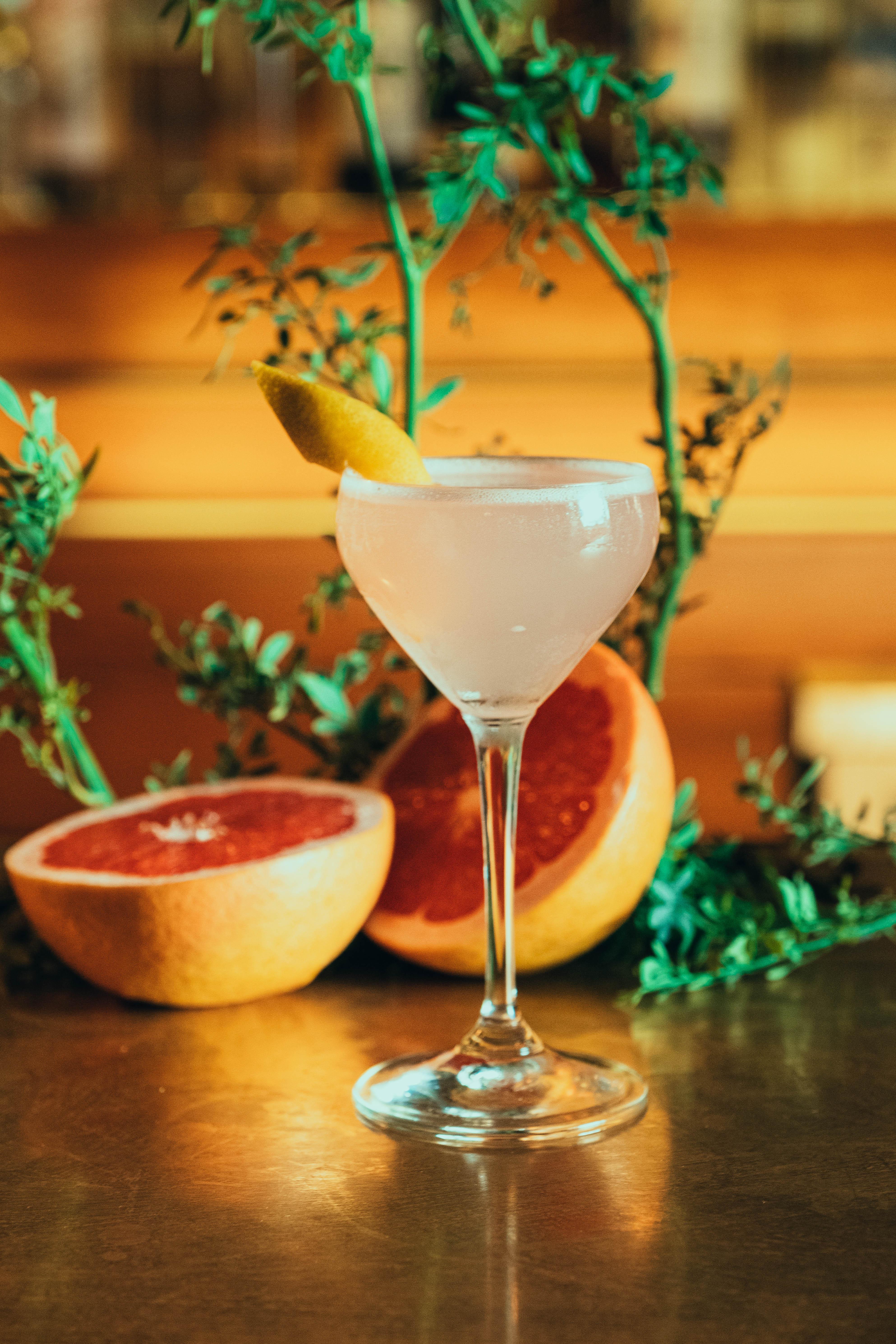 "Old Mezcalero" cocktail with a background of plants and fruit