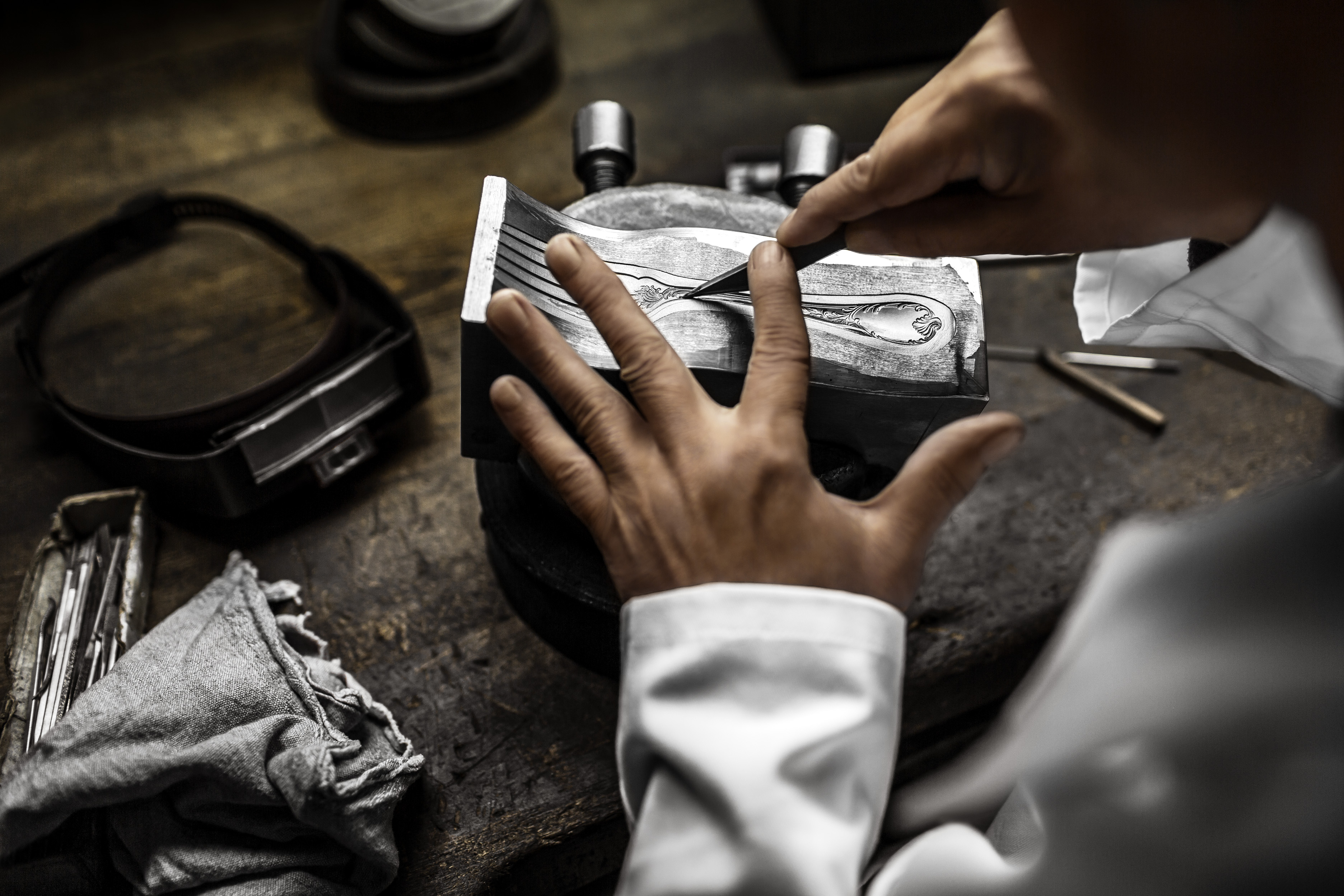 Paris Archive Exhibitions 2025 - Close-up of a Christofle craftsman engraving an intricate design into a fork in Paris.