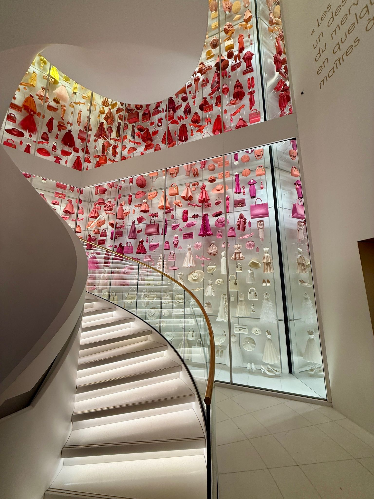 A wall displaying Christian Dior pieces in a rainbow of colours at La Galerie Dior in Paris, an archive exhibition you must visit in 2025.