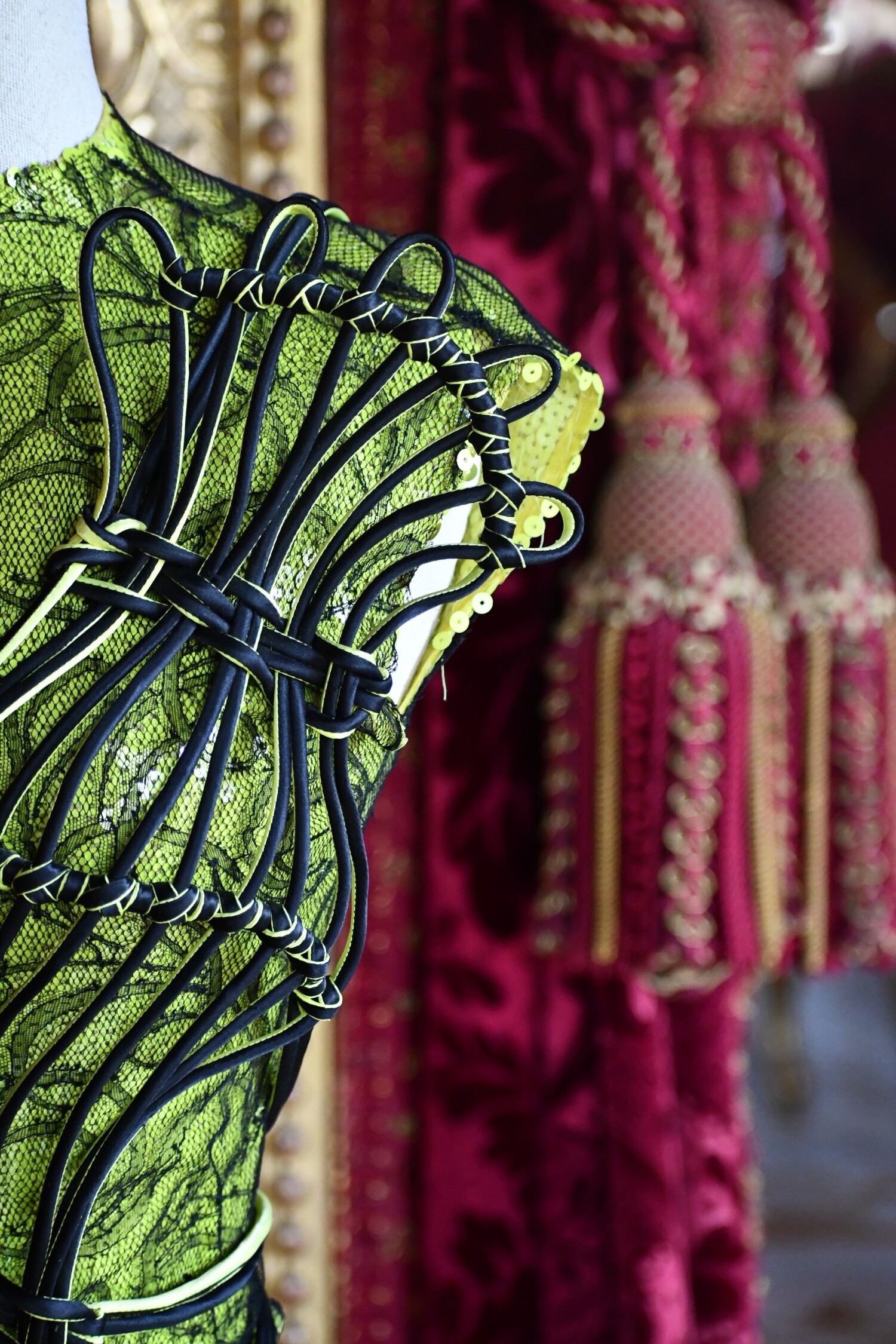 A portion of a green intricately designed Jean-Paul Gaultier garment displayed at the Louvre Couture archive exhibition in Paris, 2025.