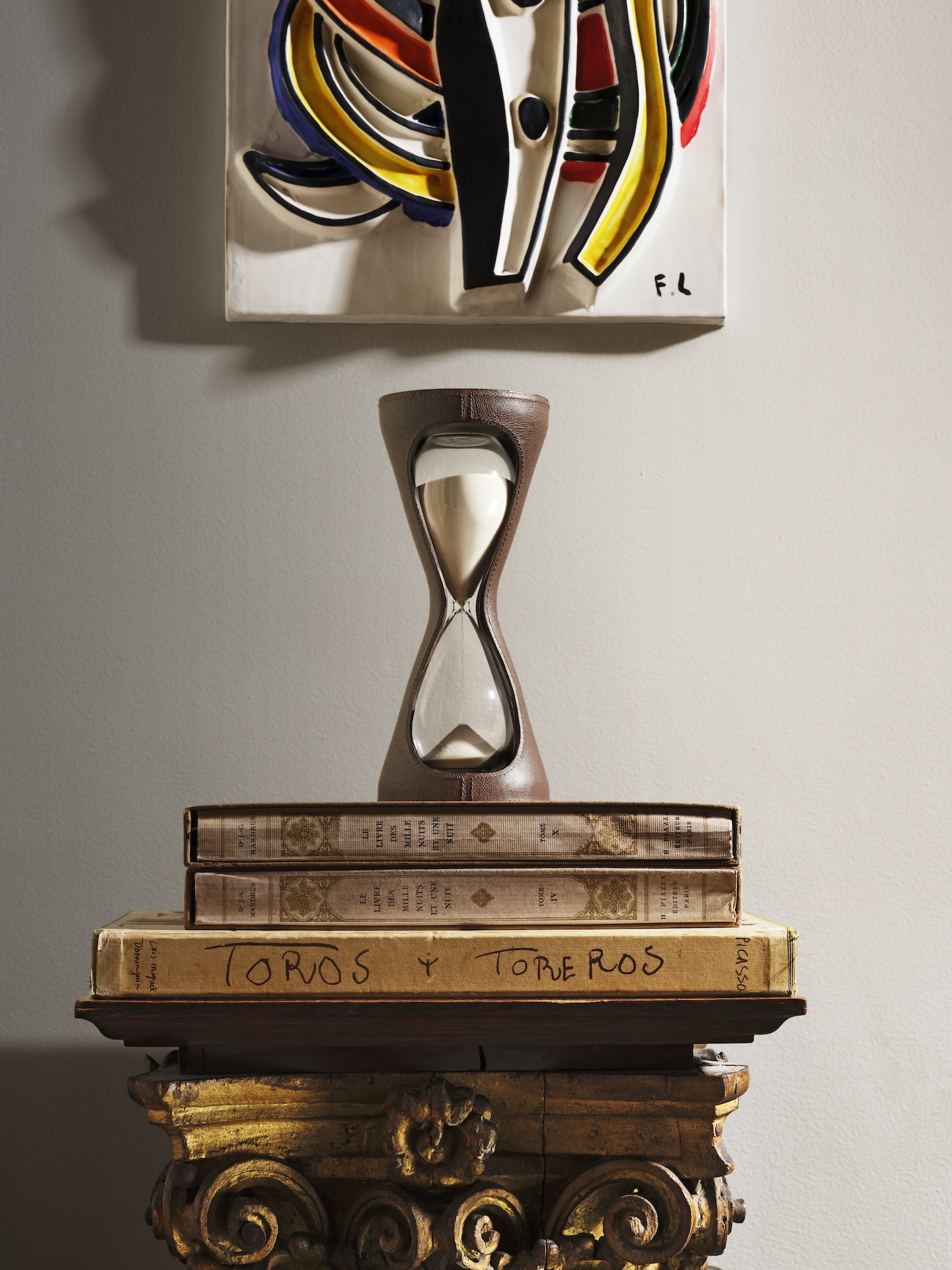 The Mirage Hourglass sat atop a pile of books on a podium as part of The Library by Maison Assouline.