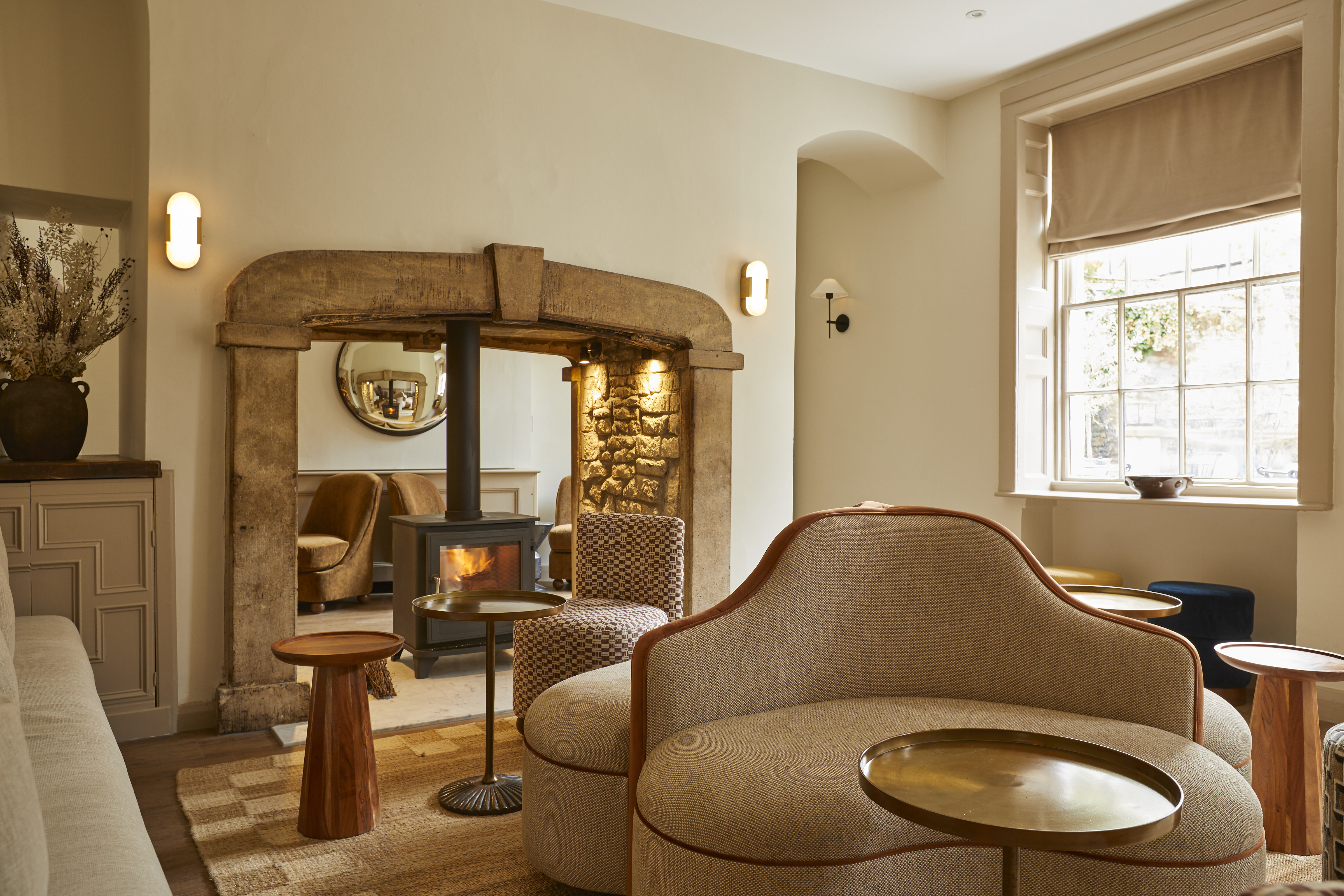 A stone archway holds a log-burning stove in The Aviary at The Feathers.
