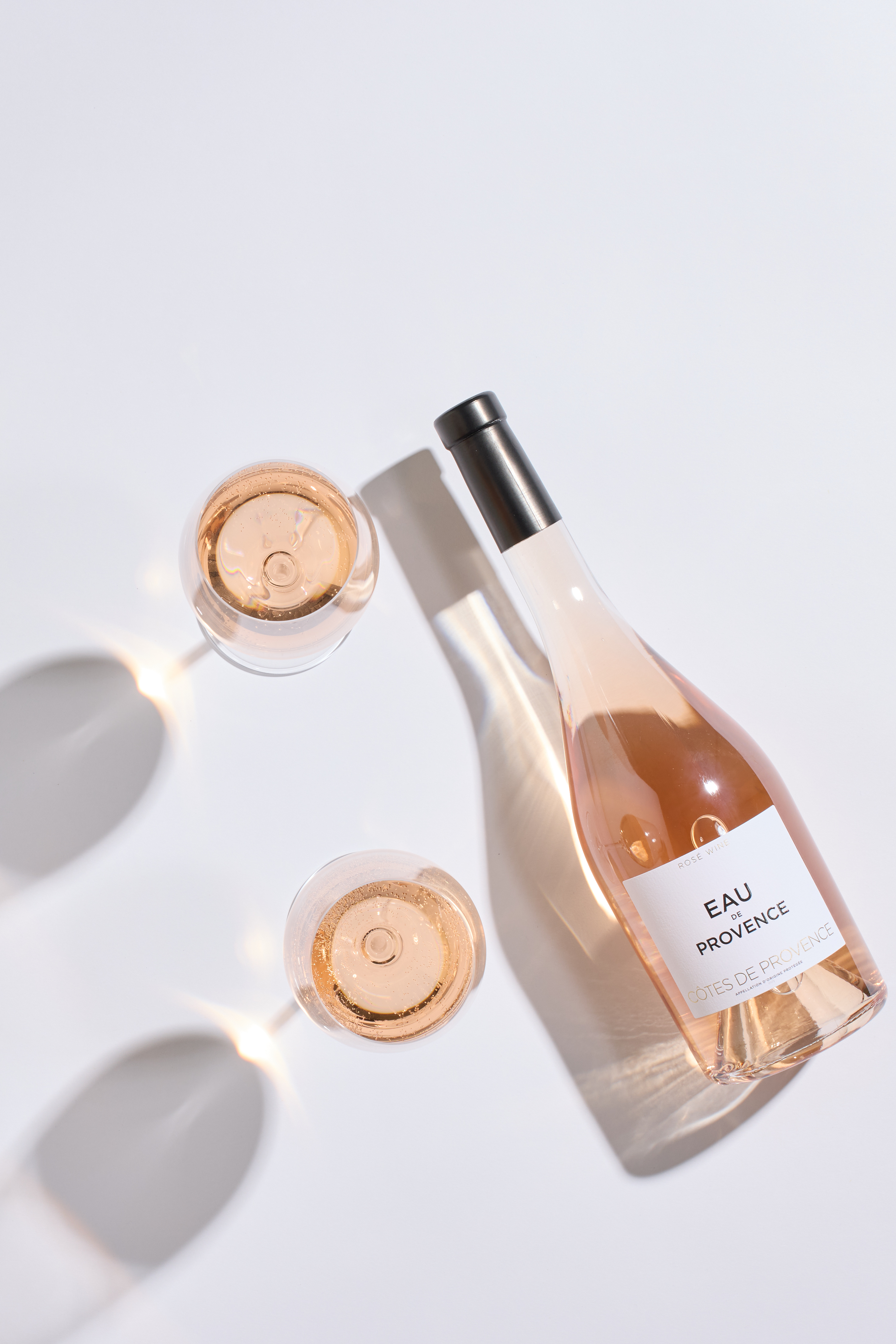 Wine bottle and two glasses of rosé marking the Eau de Provence launch.