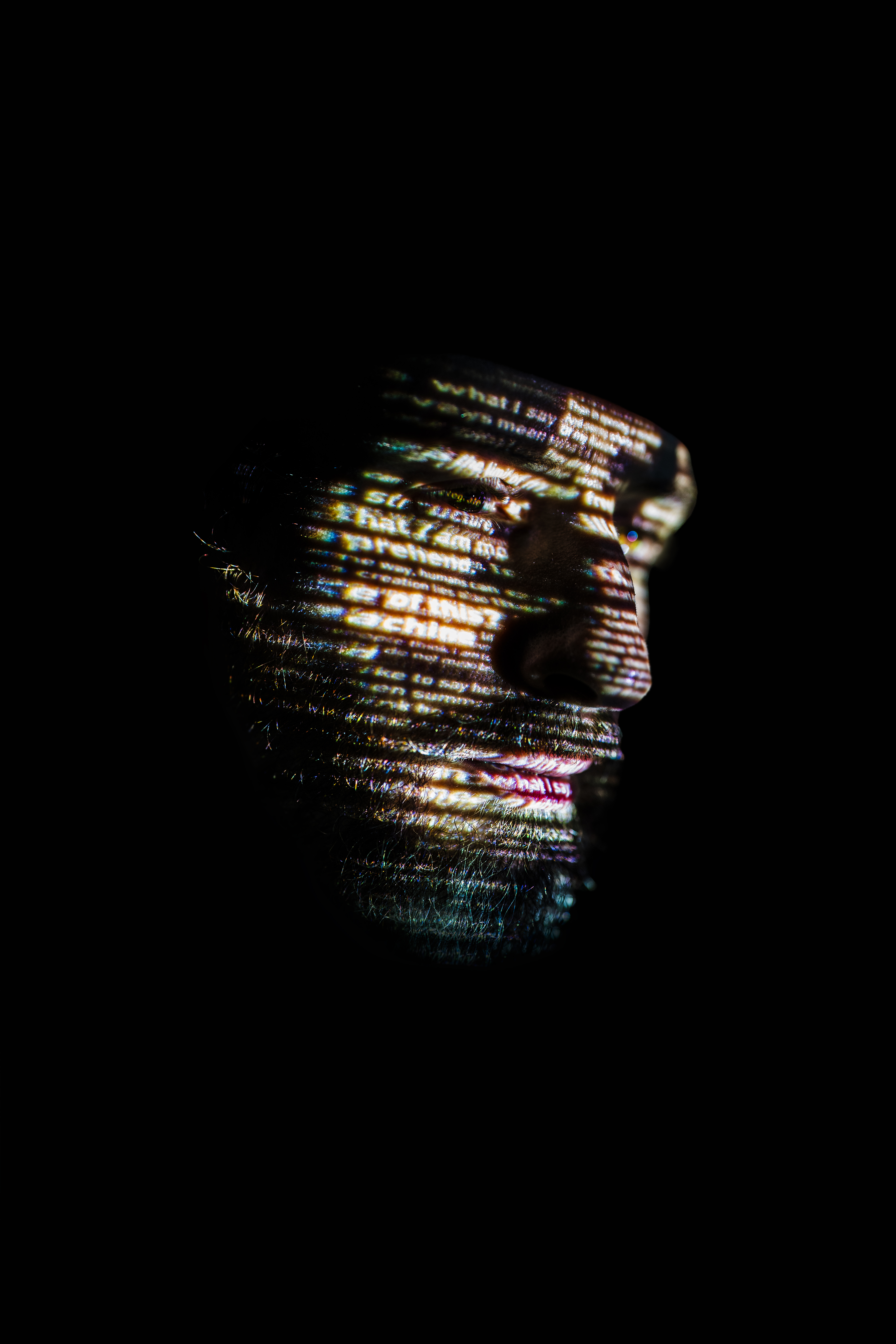 Reflections on Being by Max Cooper shows a deeply shadowed human face lit with lines of text.