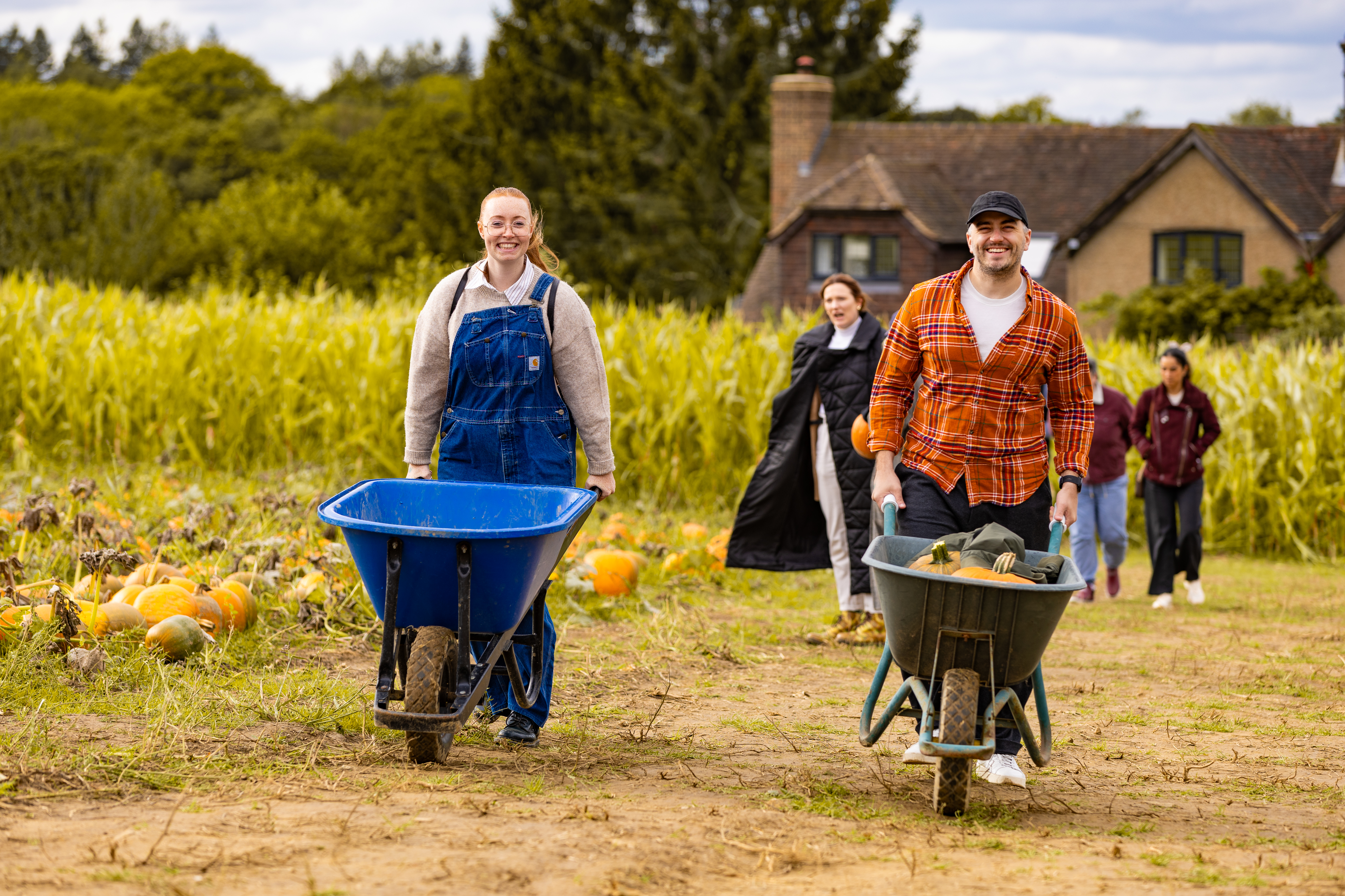 Two people with wheelbarrows at Tulleys, a pick your own farm between London and Brighton.