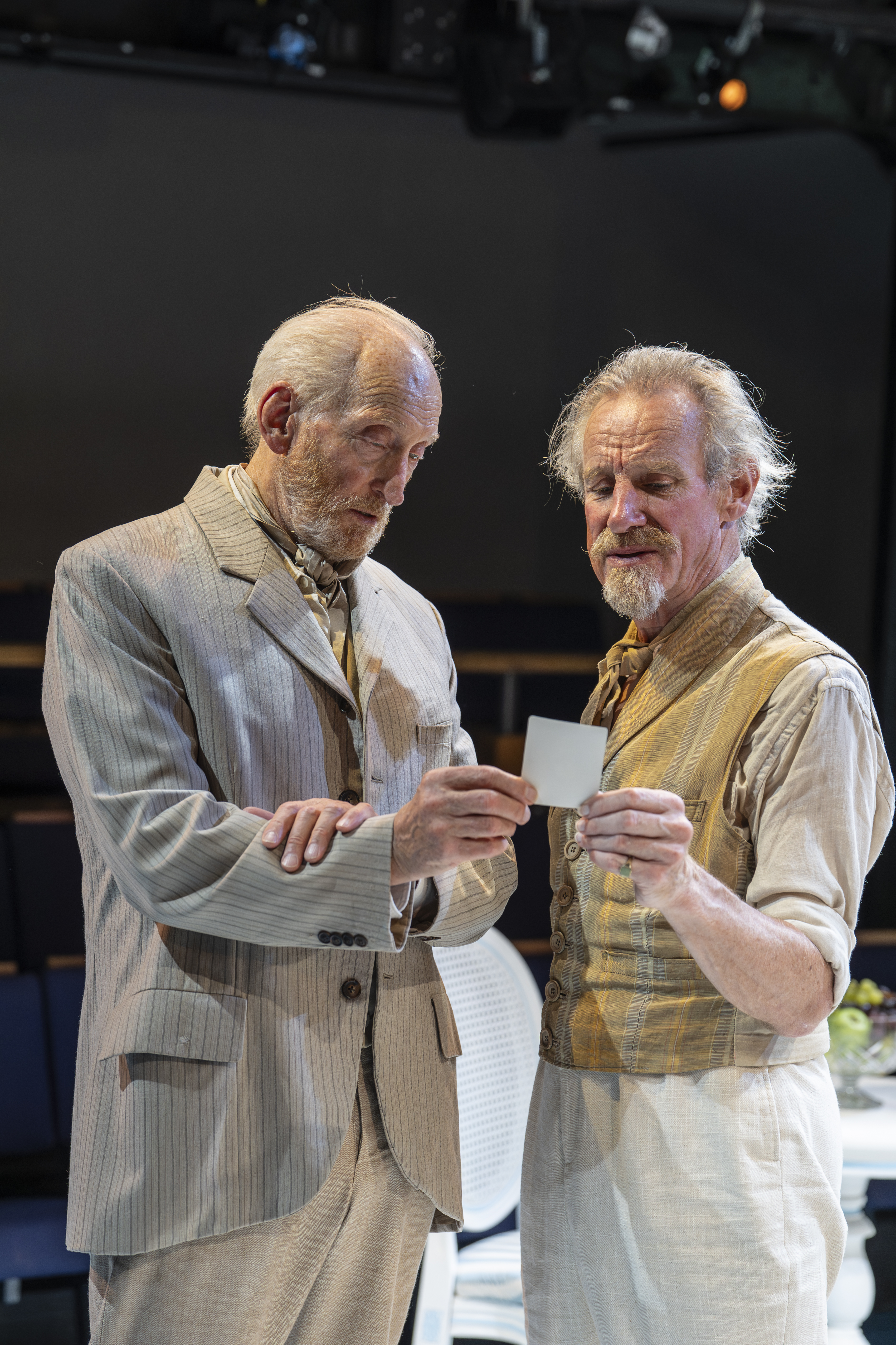 Charles Dance and Nicholas Farrell examine a photograph of Tekla, played by James, in Creditors at the Orange Tree Theatre.