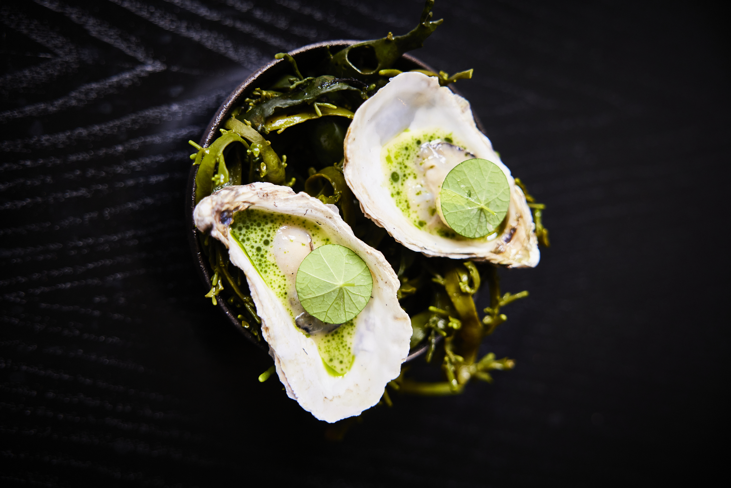 Ekstedt's signature Flambadou oysters with beurre blanc sauce. 