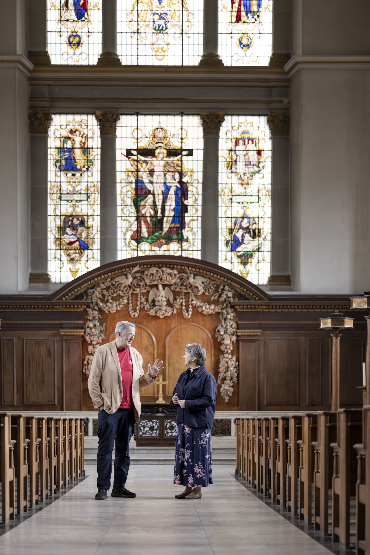 Stephen Fry and Lucy Winkett in front of the stained glass at St James's Church Piccadilly.