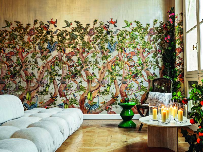 Cole & Son wallpaper - A plush sofa in front of Cole & Son's Baobab Tree wallpaper, with a table of candles.