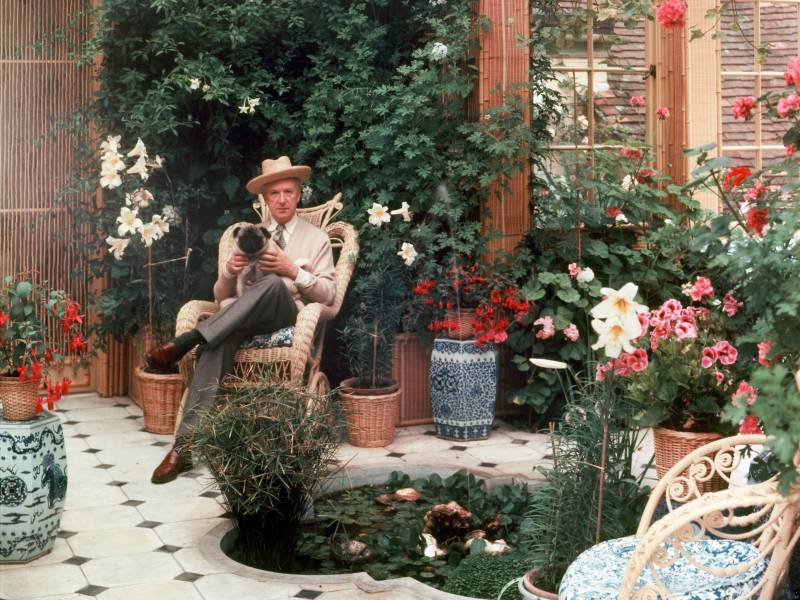 Cecil Beaton sat in the conservatory at Ashcombe House in Wiltshire