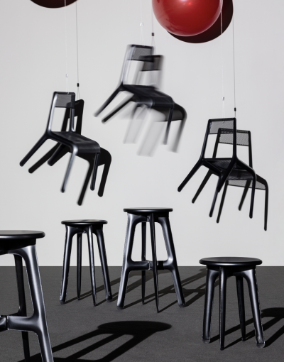 A selection of lightweight chairs drift away, tied to a pair of red balloons. 