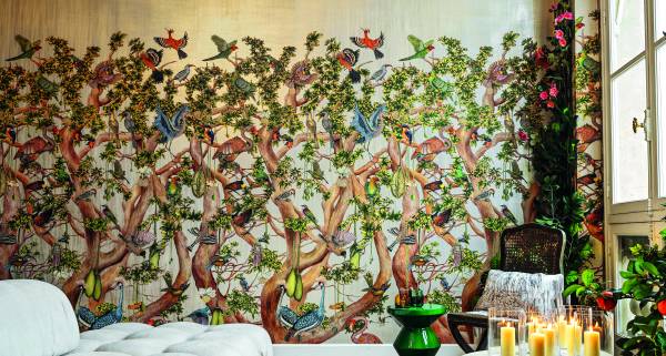 Cole & Son wallpaper - A plush sofa in front of Cole & Son's Baobab Tree wallpaper, with a table of candles.